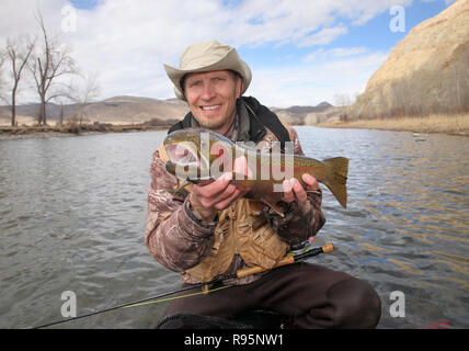 Happy fly fisherman holding large la truite arc-en-ciel Banque D'Images