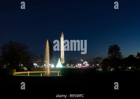 Vue sur le Washington Monument et National Mall à partir de la pelouse Sud de la Maison blanche décorée pour Noël et éclairée 12 décembre 2018 à Washington, DC. Les traces légères sont les avions décollant de l'Aéroport National Reagan sur la Rivière Potomac. Banque D'Images