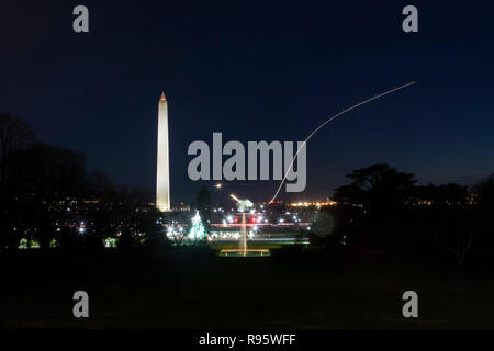 Vue sur le Washington Monument et National Mall à partir de la pelouse Sud de la Maison blanche décorée pour Noël et éclairée 12 décembre 2018 à Washington, DC. Les traces légères sont les avions décollant de l'Aéroport National Reagan sur la Rivière Potomac. Banque D'Images