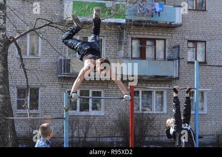 Kovrov, la Russie. 14 avril 2013. L'adolescence est engagé dans gimbarr la discipline sur une barre horizontale dans la cour d'un immeuble à plusieurs étages Banque D'Images