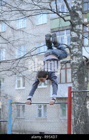 Kovrov, la Russie. 14 avril 2013. L'adolescence est engagé dans gimbarr la discipline sur une barre horizontale dans la cour d'un immeuble à plusieurs étages Banque D'Images