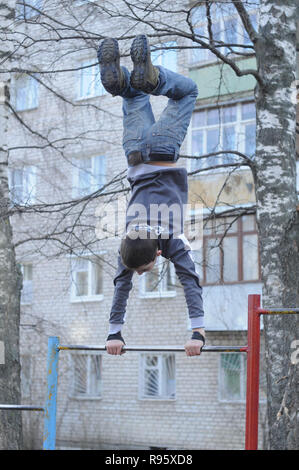 Kovrov, la Russie. 14 avril 2013. L'adolescence est engagé dans gimbarr la discipline sur une barre horizontale dans la cour d'un immeuble à plusieurs étages Banque D'Images