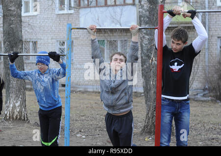 Kovrov, la Russie. 14 avril 2013. L'adolescence est engagé dans gimbarr la discipline sur une barre horizontale dans la cour d'un immeuble à plusieurs étages Banque D'Images