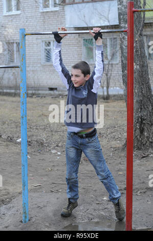 Kovrov, la Russie. 14 avril 2013. L'adolescence est engagé dans gimbarr la discipline sur une barre horizontale dans la cour d'un immeuble à plusieurs étages Banque D'Images