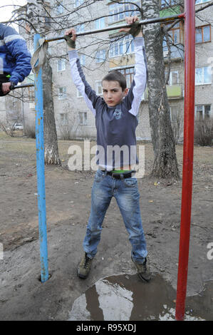 Kovrov, la Russie. 14 avril 2013. L'adolescence est engagé dans gimbarr la discipline sur une barre horizontale dans la cour d'un immeuble à plusieurs étages Banque D'Images