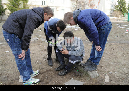 Kovrov, la Russie. 14 avril 2013. Les adolescents qui sont engagés dans gimbarr discipline smartphone regarder dans la cour d'un bâtiment résidentiel à plusieurs étages Banque D'Images