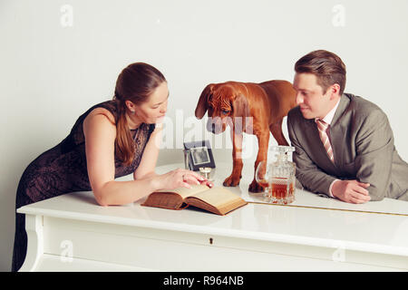 Homme d'affaires réussi avec sa femme et son chien. Le concept d'une vie heureuse et réussie. Banque D'Images