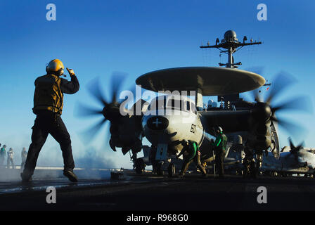 Un poste de pilotage d'aéronefs guides directeur un E-2C Hawkeye affecté à l' 'Golden Hawks de l'Escadron aéroporté de détection lointaine de l'opérateur l'un l'un deux (VFF-112) sur une catapulte à vapeur propulsé pour lancer sur le poste de pilotage de la classe Nimitz porte-avions USS JOHN C. STENNIS (CVN 74). U.S. Navy photo by Mass Communication Specialist 3rd Class Jon Hyde Banque D'Images