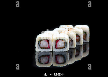 Rouleaux de sushi avec le saumon, le thon, le concombre et les oignons verts sur fond noir Banque D'Images