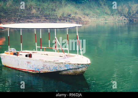 Bateau en bois blanc à river bank, entouré de forêts de mangrove. Jungle Cruise Delta du fleuve. Pêcheur et barques touristiques. L'Assam Inde tourisme Banque D'Images