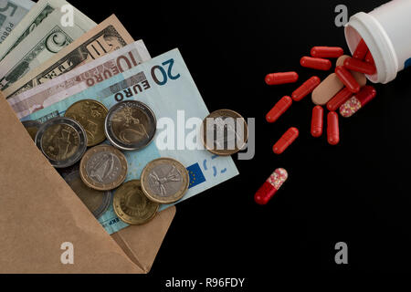 Euro et dollar monnaie dans l'enveloppe contre comprimés dispersés, pilules, gélules. Les frais médicaux, l'achat de médicaments Banque D'Images