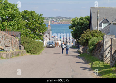 Regardant vers le bas de la colline de la nonnerie. F​Oot les passagers, au départ d'Iona, de ferry pour Fionnphort, Mull. Pour rendre le quai, Port Ronain. Banque D'Images