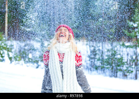 Portrait of cheerful Pretty woman throwing snow dans l'air. Vacances d'hiver concept Banque D'Images