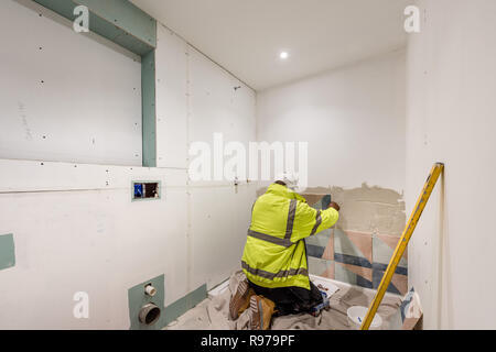 Carrelage d'un mur dans une nouvelle salle de bains Banque D'Images