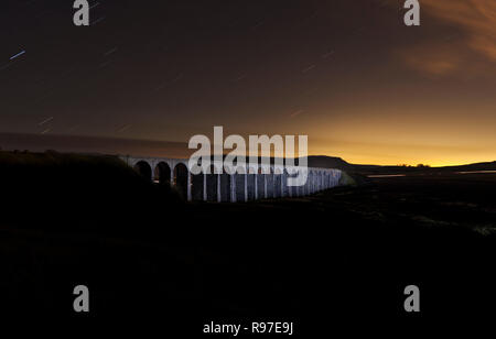 Ribblehead viaduc sur la ligne de chemin de fer s'installer à Carlisle de nuit courts par la lumière peinture avec un chalumeau. Penyghent est derrière Banque D'Images