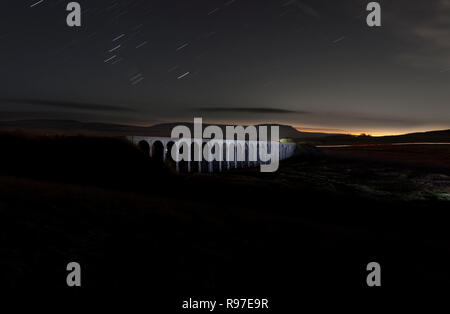 Ribblehead viaduc sur la ligne de chemin de fer s'installer à Carlisle de nuit courts par la lumière peinture avec un chalumeau. Penyghent est derrière Banque D'Images