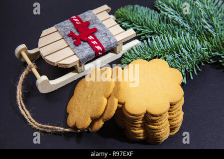 Biscuits au gingembre, branches de sapin et Père Noël, traîneau, sur un fond sombre Banque D'Images