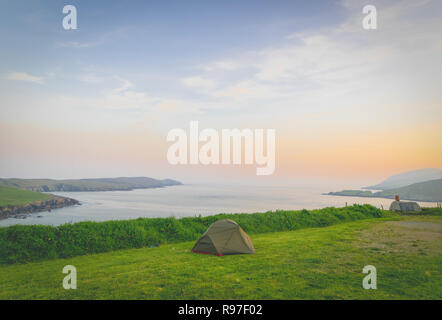 Tente verte en premier plan avec vue panoramique sur la mer en Irlande du Nord Banque D'Images