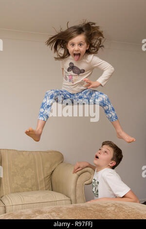 Les enfants, frère et soeur à propos de saut sur des meubles, de la plongée et de sauter, d'être hyperactifs, beaucoup d'énergie, de jouer ensemble Banque D'Images
