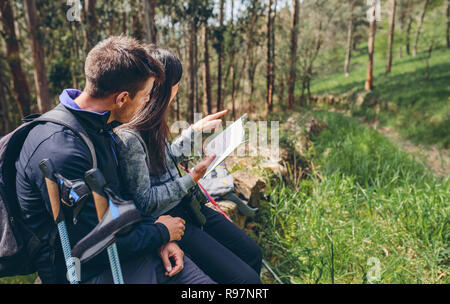 Couple assis trekking en regardant une carte Banque D'Images