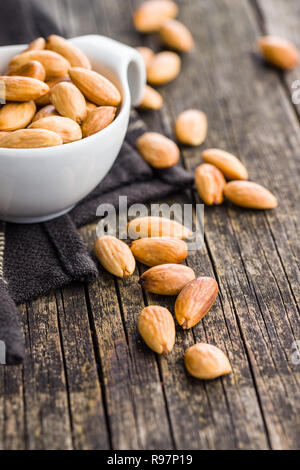 Salé amandes rôties sur la vieille table en bois. Banque D'Images