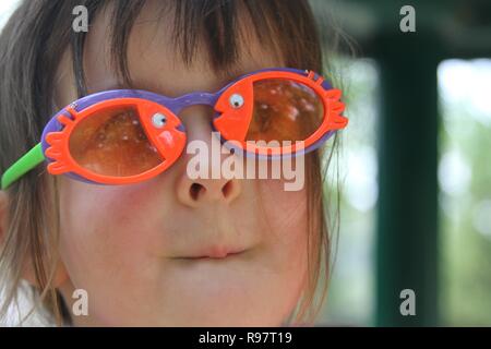 Petite fille avec des poissons colorés sunglasses Banque D'Images