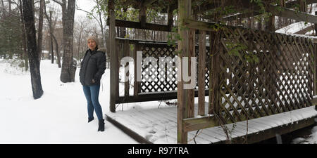 Femme Asiatique avec tricot beige hat standing in snow Banque D'Images