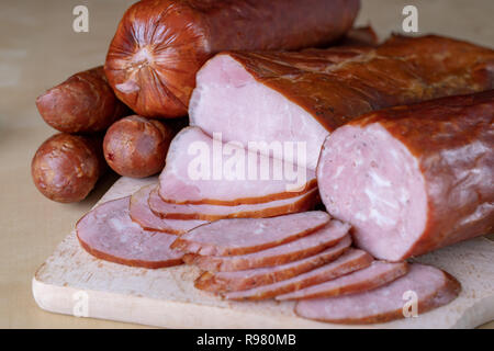 De délicieuses saucisses fraîches sur la table de la cuisine. Traite préparé pour la cérémonie d'accueil. Fond clair. Banque D'Images