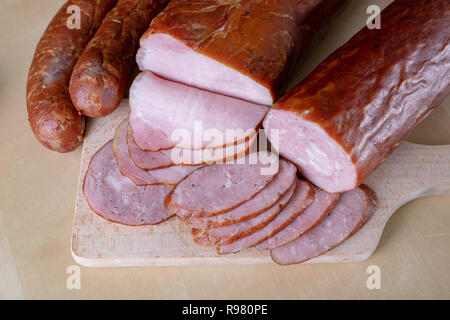 De délicieuses saucisses fraîches sur la table de la cuisine. Traite préparé pour la cérémonie d'accueil. Fond clair. Banque D'Images