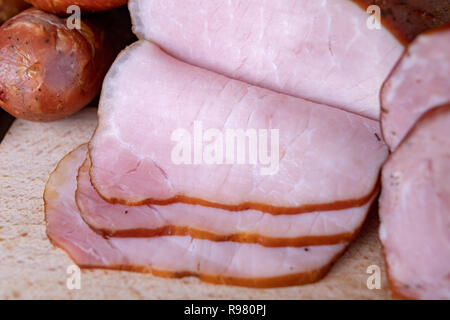 De délicieuses saucisses fraîches sur la table de la cuisine. Traite préparé pour la cérémonie d'accueil. Fond clair. Banque D'Images