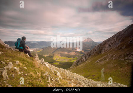 L'homme assis dans le rebord d'une montagne à l'horizon en parc naturel Urkiola, Pays basque Banque D'Images