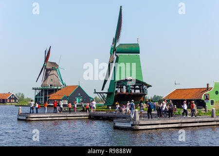 Les touristes à marcher le long des moulins à vent traditionnel néerlandais à Zaanse Schans en Pays-Bas Banque D'Images