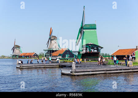 Les touristes à marcher le long des moulins à vent traditionnel néerlandais à Zaanse Schans en Pays-Bas Banque D'Images