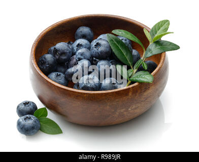 Bleuets frais dans un bol en bois avec des feuilles isolées sur fond blanc. Macro, studio shot Banque D'Images