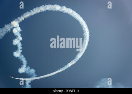 La forme de la lettre D gauche par les traînées de fumée d'un avion acrobatique contre un ciel bleu Banque D'Images