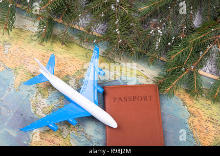 Concept de Noël - voyage. Branches de sapin avec de la neige, des cartes, passeport et toy airplane Banque D'Images