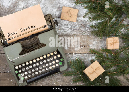 Concept de Noël - Machine à écrire avec l'inscription 'Cher Père Noël, cadeaux et des branches de sapin sur une table en bois Banque D'Images