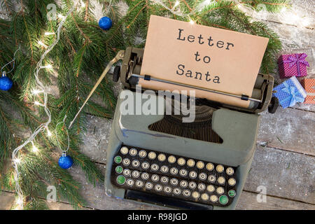 Concept de Noël - Machine à écrire avec l'inscription "Lettre au Père", des boîtes-cadeaux, Garland et branches de sapin sur une table en bois Banque D'Images