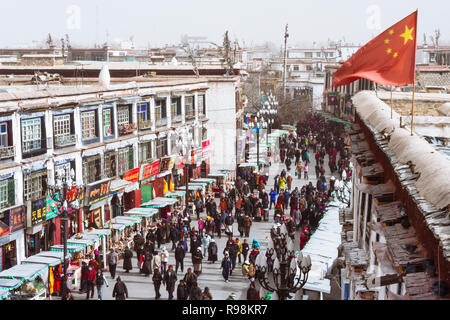 Lhassa, dans la région autonome du Tibet, Chine : un drapeau chinois sur les vagues de personnes marchant le long d'une des rues principales de la Barkhor district. Banque D'Images