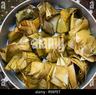 Aliments cuits à / dessert enveloppés de feuilles de banane dans la banane et le riz gluant à la vapeur après Banque D'Images