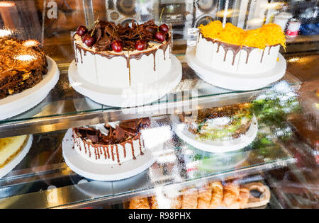 Dans showcase / gâteau gâteau bac en verre affichage à rayon boulangerie pâtisserie - vitrine avec des bonbons les gâteaux au chocolat selective focus Banque D'Images