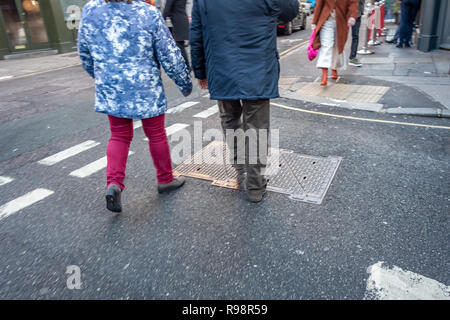 Excentriquement vêtue une femme et un homme âgés marchant crossing Road à Londres Banque D'Images