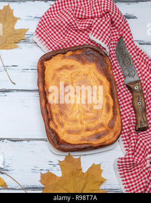 Tarte rectangulaire entière de fromage cottage et de citrouille sur une table en bois blanc, vue du dessus Banque D'Images