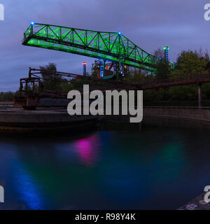 Grue allumé en début de soirée avec une piscine et réflexions à la Duisburg Landschafts Park Banque D'Images