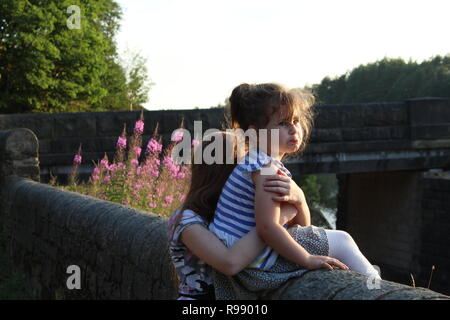 Deux enfants en voyant le peak district est assis sur un mur Banque D'Images