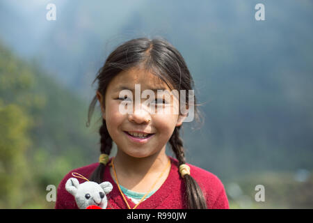 Fille de l'himalaya posent pour l'appareil photo avec doudou et sourire Banque D'Images