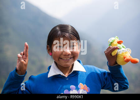 Fille de l'himalaya posent pour l'appareil photo avec doudou et sourire Banque D'Images