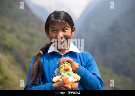 Fille de l'himalaya posent pour l'appareil photo avec doudou et sourire Banque D'Images