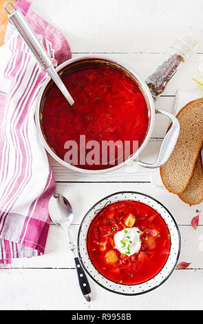 Bortsch Russe Ukrainien traditionnel avec des haricots blancs sur le bol. Soupe de betteraves. Assiette de soupe de racine de betterave rouge sur tableau blanc le bortsch. Ukra traditionnels Banque D'Images