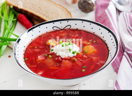 Bortsch Russe Ukrainien traditionnel avec des haricots blancs sur le bol. Soupe de betteraves. Assiette de soupe de racine de betterave rouge sur tableau blanc le bortsch. Ukra traditionnels Banque D'Images